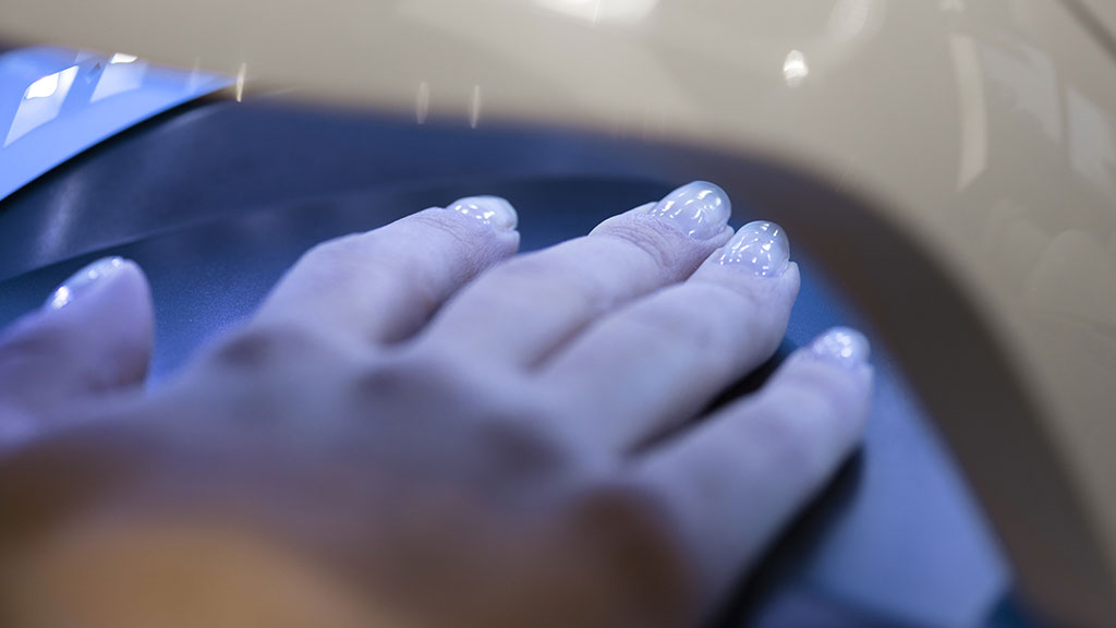 Hand placed inside a UV nail lamp to cure gel nail polish