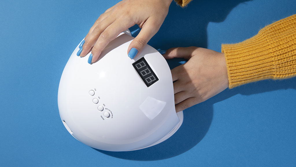 Hand placed inside a UV nail lamp to cure gel nail polish