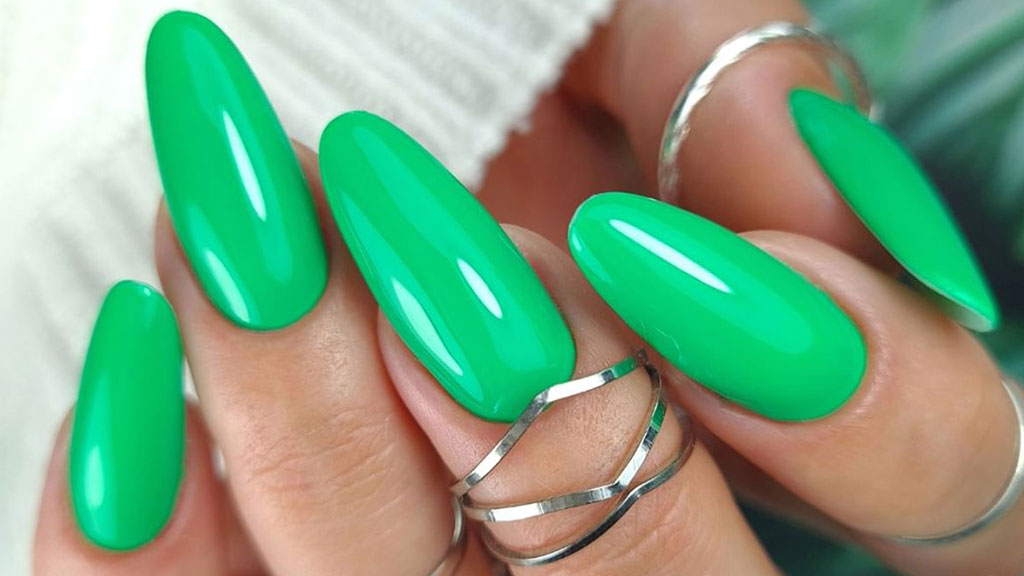 Green gel nails with a glossy finish in a modern manicure trend.